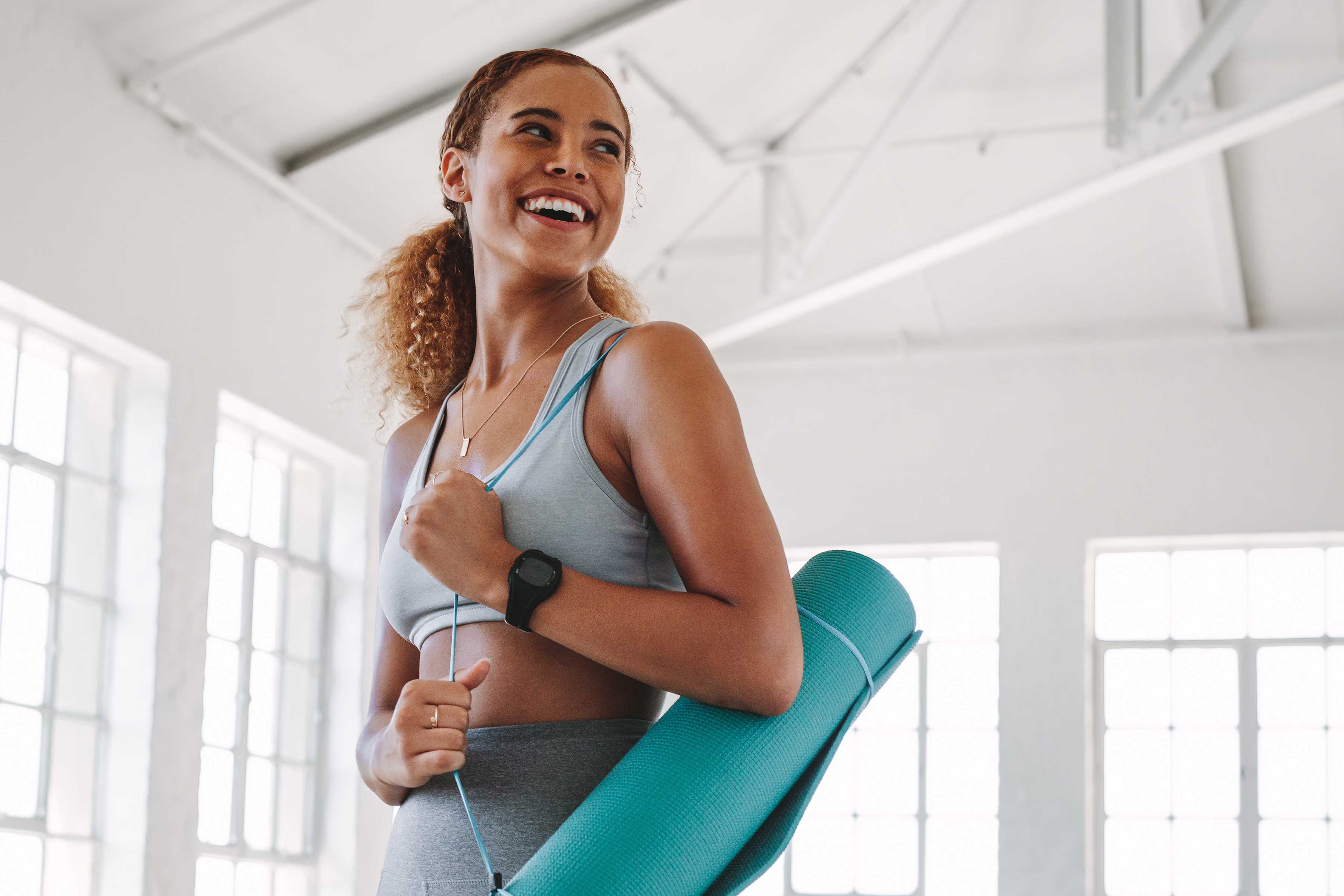 girl smiling with yoga mat